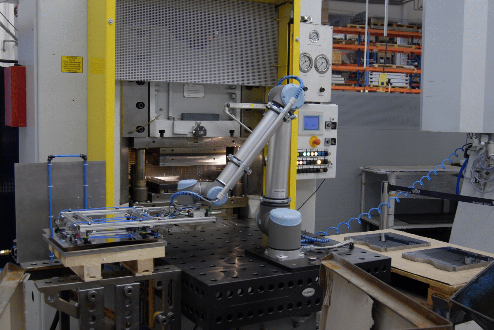 Dank Robotertechnik effizient fertigen: der Roboter UR10 übernimmt die Bestückung der Maschine und das Abstapeln der Blechteile